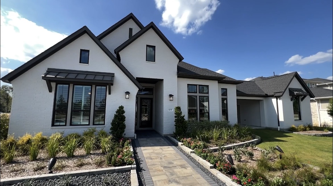 White brick house with landscaped front walk